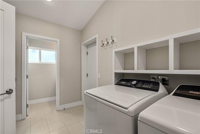 clothes washing area with light tile patterned floors, baseboards, laundry area, and independent washer and dryer