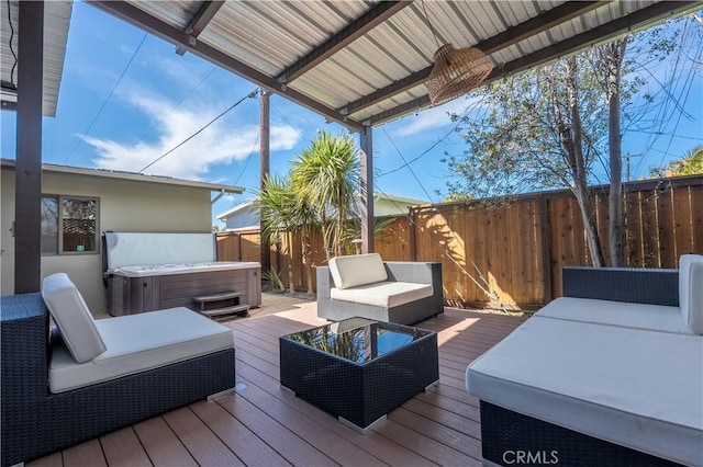wooden terrace featuring a fenced backyard, an outdoor living space, and a hot tub