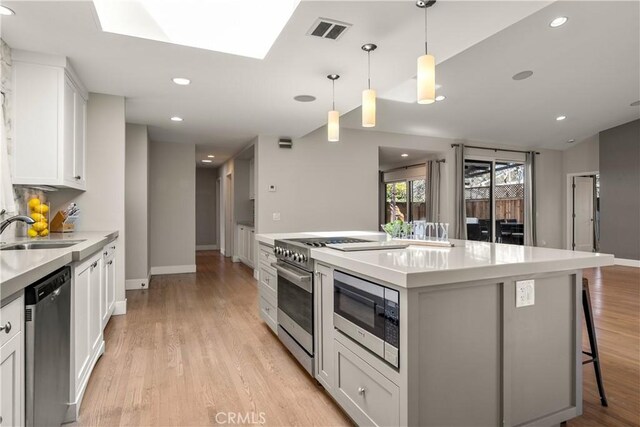 kitchen with visible vents, recessed lighting, white cabinetry, a sink, and stainless steel appliances