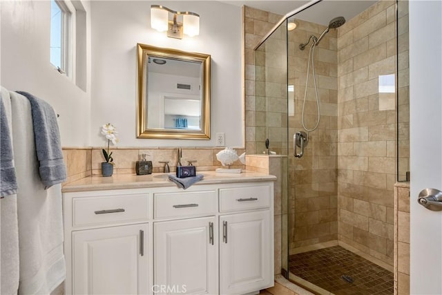 full bathroom featuring visible vents, a shower stall, and vanity