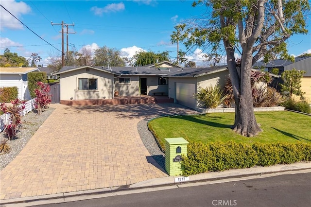 single story home featuring fence, stucco siding, a front lawn, a garage, and decorative driveway