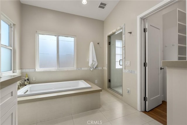 bathroom with tile patterned flooring, visible vents, a stall shower, and a garden tub