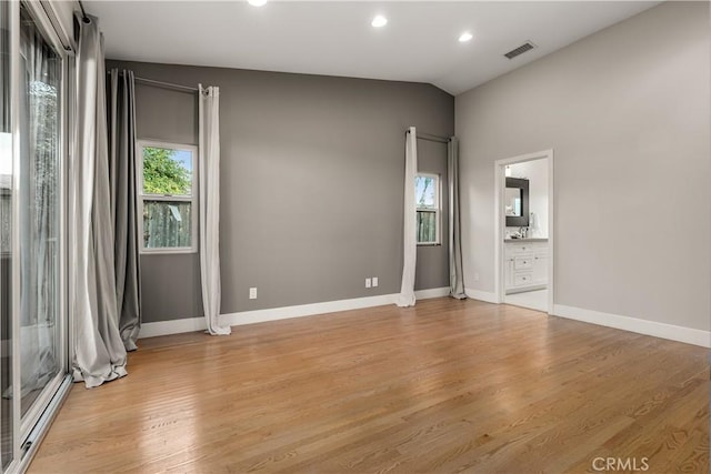 spare room featuring a wealth of natural light, light wood-style floors, and vaulted ceiling