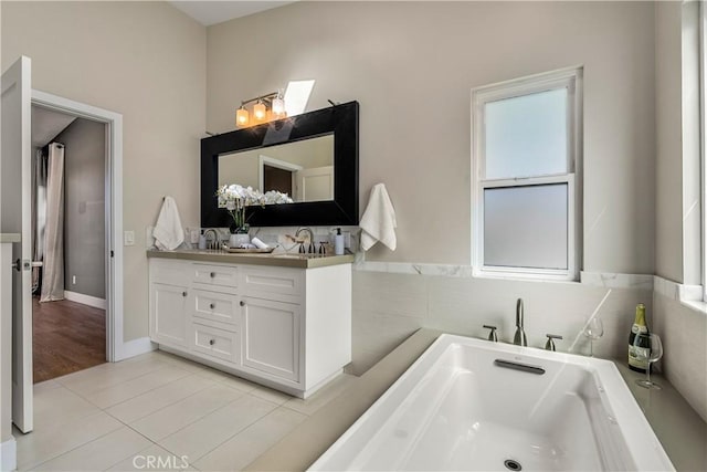 full bath featuring vanity, tile patterned floors, and a freestanding bath