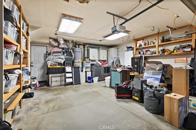 garage with secured water heater, a garage door opener, and washer and clothes dryer