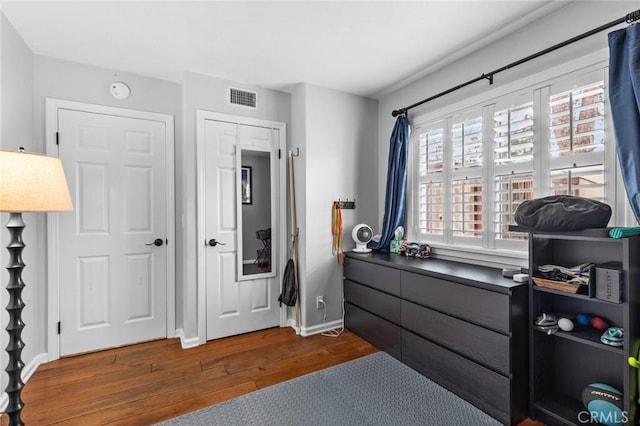 bedroom with visible vents, baseboards, and dark wood-type flooring