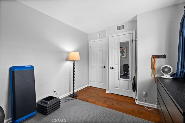 miscellaneous room with wood finished floors, baseboards, and visible vents