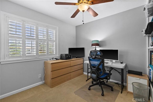 office space featuring ceiling fan, baseboards, and light carpet