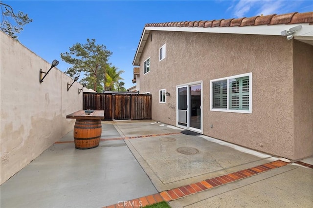 exterior space with stucco siding, a patio, and a fenced backyard