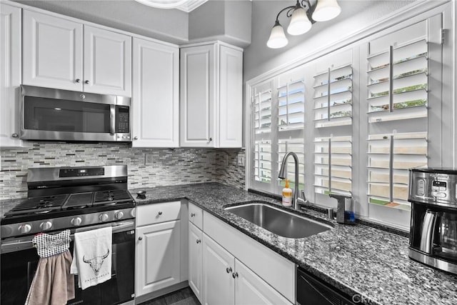 kitchen with tasteful backsplash, white cabinets, stainless steel appliances, and a sink