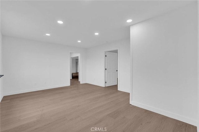 empty room featuring recessed lighting, baseboards, and wood finished floors