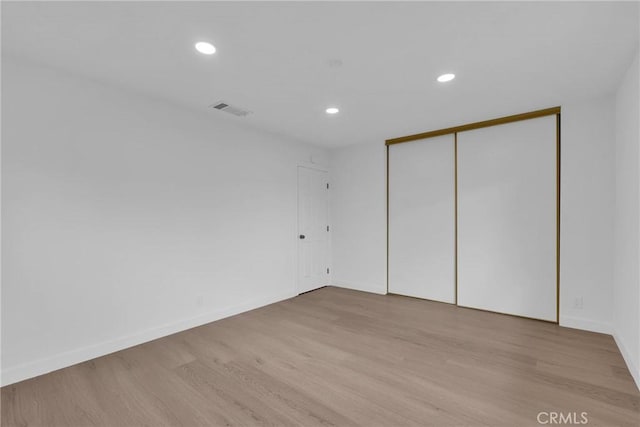 unfurnished room with recessed lighting, visible vents, baseboards, and wood finished floors