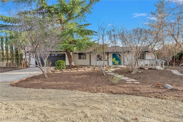 view of front of property featuring driveway, an attached garage, and stucco siding