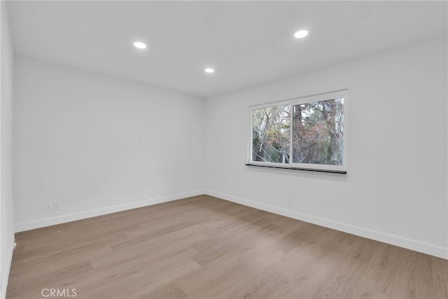 spare room with recessed lighting, baseboards, and wood finished floors