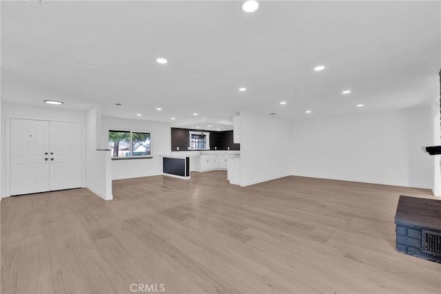 unfurnished living room with baseboards, light wood-style flooring, and recessed lighting