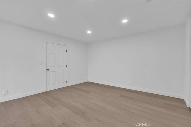 spare room with recessed lighting, baseboards, and wood finished floors