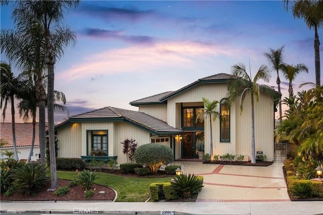 view of front facade featuring a garage, concrete driveway, and a front yard