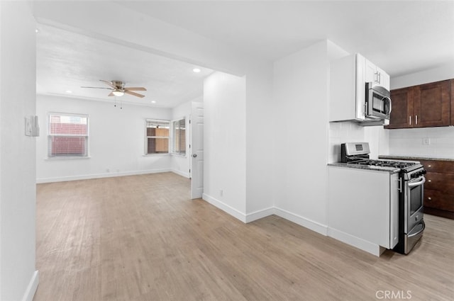 kitchen featuring stainless steel appliances, light wood-style flooring, decorative backsplash, dark brown cabinetry, and baseboards