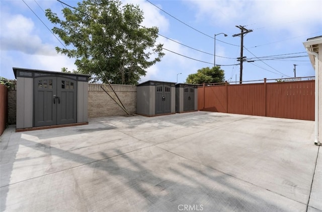 view of patio / terrace featuring a storage shed, a fenced backyard, and an outbuilding