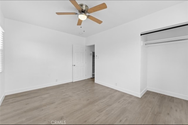 unfurnished bedroom with a closet, wood finished floors, a ceiling fan, and baseboards