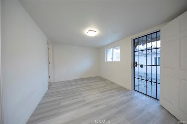 unfurnished room featuring light wood finished floors and baseboards