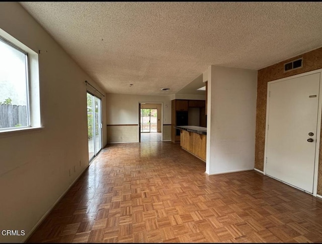 unfurnished room featuring visible vents, baseboards, and a textured ceiling