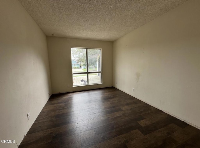 spare room with dark wood-style floors and a textured ceiling