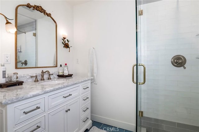 bathroom featuring a shower stall, vanity, and baseboards