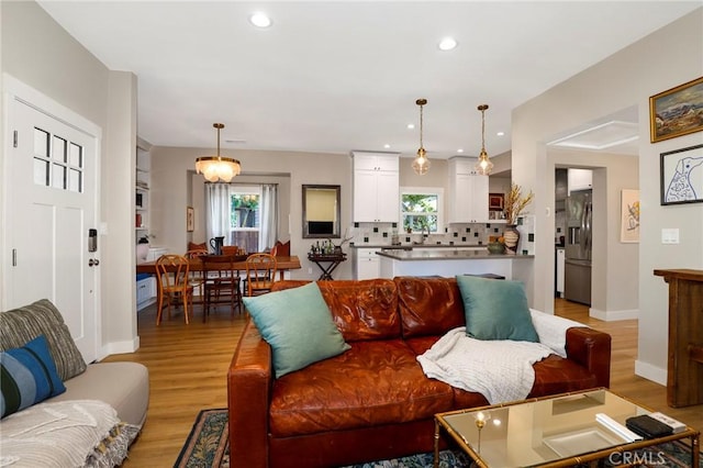 living area featuring light wood-style floors, recessed lighting, and baseboards