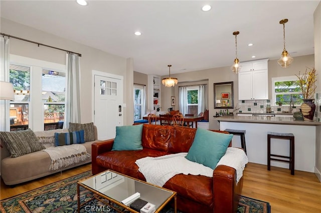 living room featuring a healthy amount of sunlight, light wood-style floors, and recessed lighting