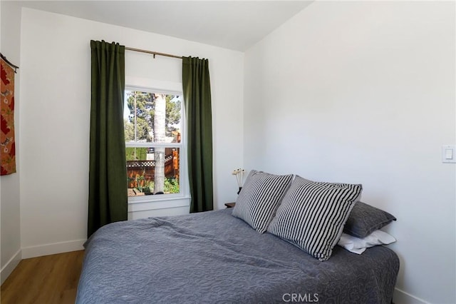 bedroom featuring baseboards and wood finished floors