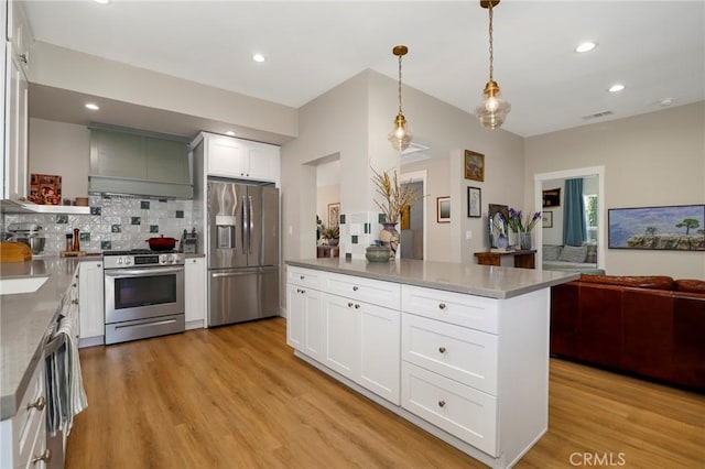 kitchen with visible vents, appliances with stainless steel finishes, light wood-type flooring, custom exhaust hood, and tasteful backsplash