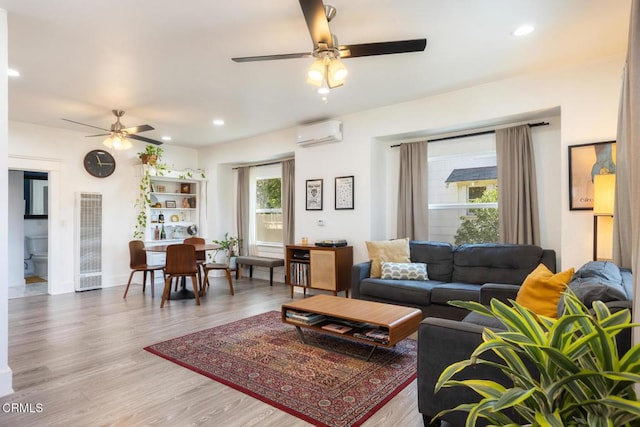 living room with baseboards, a ceiling fan, wood finished floors, a wall mounted air conditioner, and recessed lighting