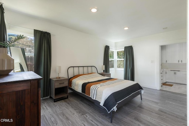 bedroom featuring multiple windows, wood finished floors, and recessed lighting