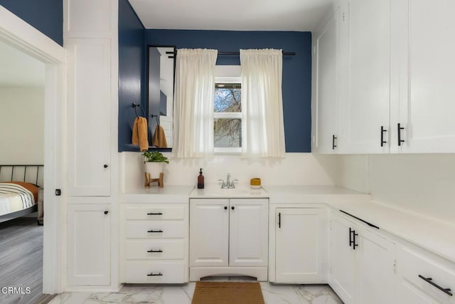 bar featuring marble finish floor, decorative backsplash, and a sink