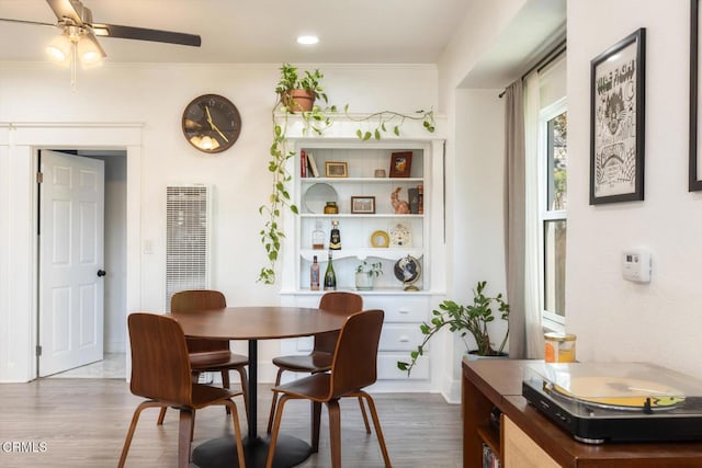 dining area with crown molding, a ceiling fan, and wood finished floors