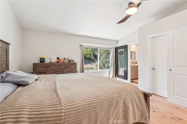 bedroom featuring light wood-style floors, lofted ceiling, ceiling fan, and ensuite bathroom