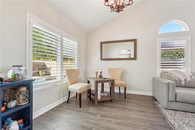 living area with lofted ceiling, light wood-style flooring, baseboards, and an inviting chandelier