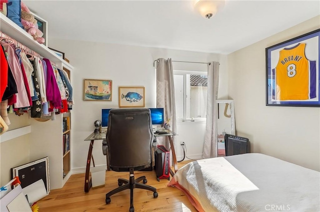 bedroom with wood finished floors and baseboards