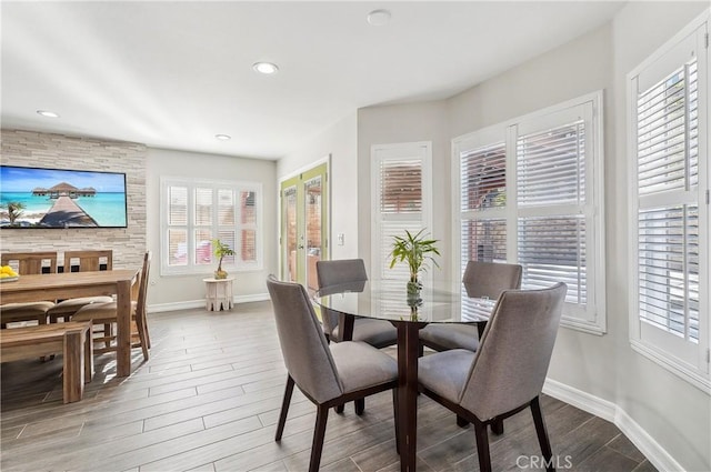 dining area featuring baseboards, wood finished floors, and recessed lighting