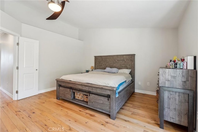 bedroom with a ceiling fan, light wood-style flooring, and baseboards