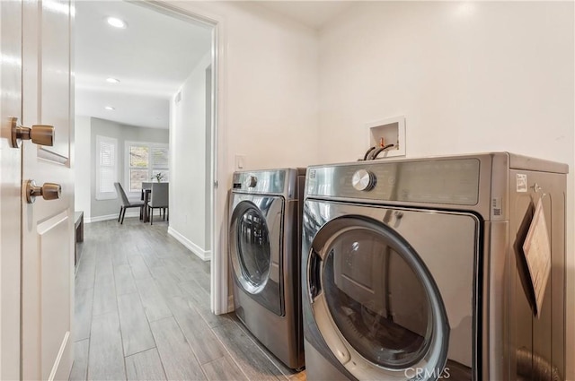 laundry room with laundry area, baseboards, wood tiled floor, washing machine and dryer, and recessed lighting