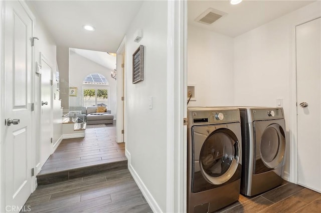 laundry area featuring washing machine and clothes dryer, recessed lighting, visible vents, wood tiled floor, and laundry area