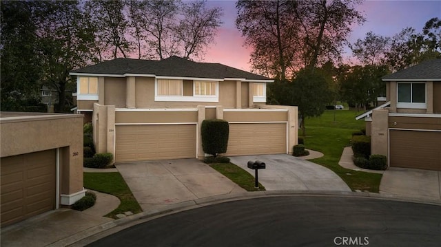 view of front of home featuring a garage, concrete driveway, and stucco siding