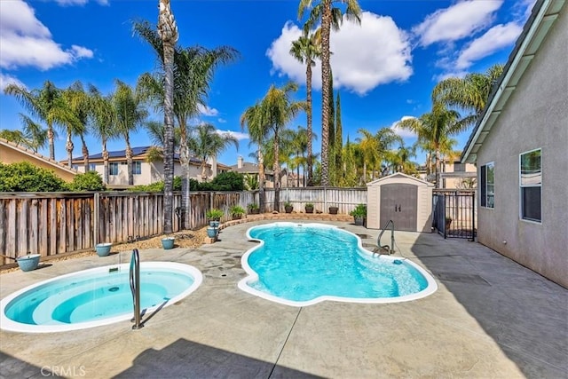 view of pool featuring a patio, a fenced backyard, an in ground hot tub, an outdoor structure, and a shed