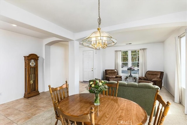 dining area featuring light tile patterned floors and arched walkways