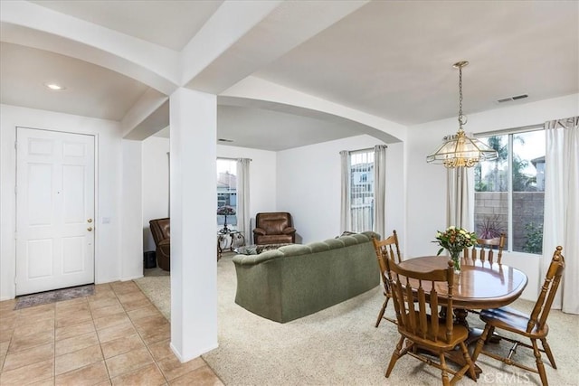 dining area featuring arched walkways, visible vents, an inviting chandelier, and light tile patterned flooring