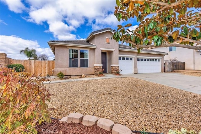 view of front of property with an attached garage, fence, concrete driveway, and stucco siding