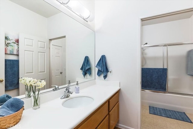 bathroom featuring enclosed tub / shower combo, vanity, and baseboards