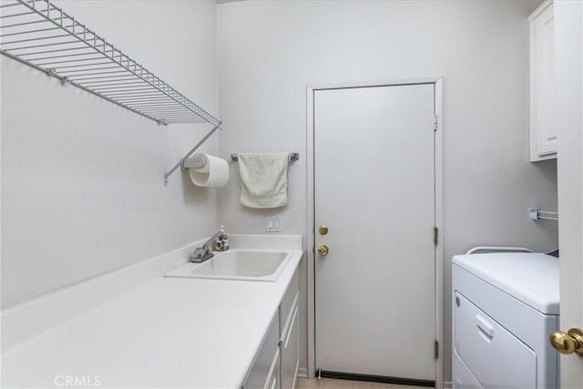 laundry room featuring cabinet space, a sink, and washer / dryer